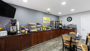 A breakfast area with a coffee machine, cereal, and a sign for Daybreak Breakfast. - Days Inn by Wyndham Ukiah (Ukiah)