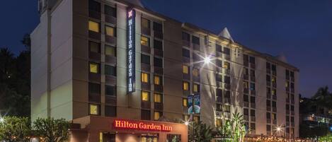 A multi-story hotel with a prominent "Hilton Garden Inn" sign at the entrance.