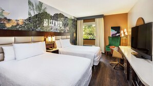 A hotel room with two beds, a desk, a television, and a mural of Hollywood. - Hilton Garden Inn Los Angeles/Hollywood (Los Angeles)