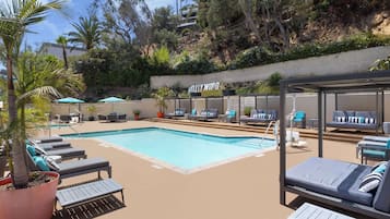 Een buitenzwembad en ligstoelen