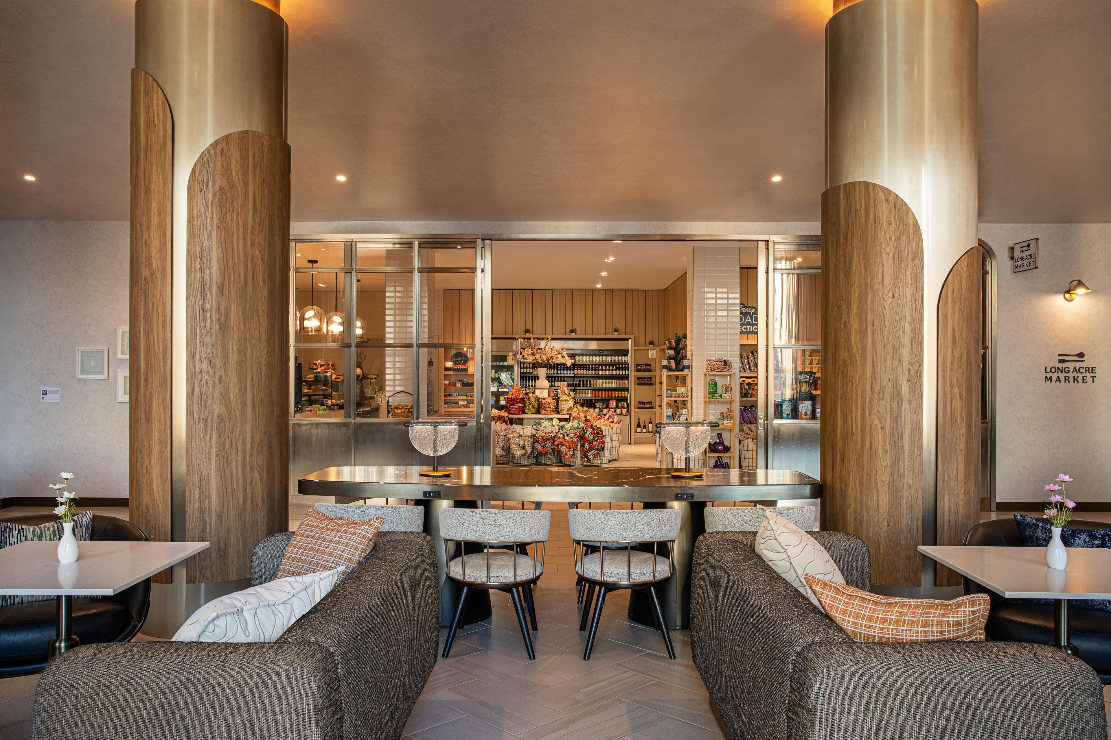 Un interior moderno con una zona de bar, asientos y vistas al mercado contiguo.