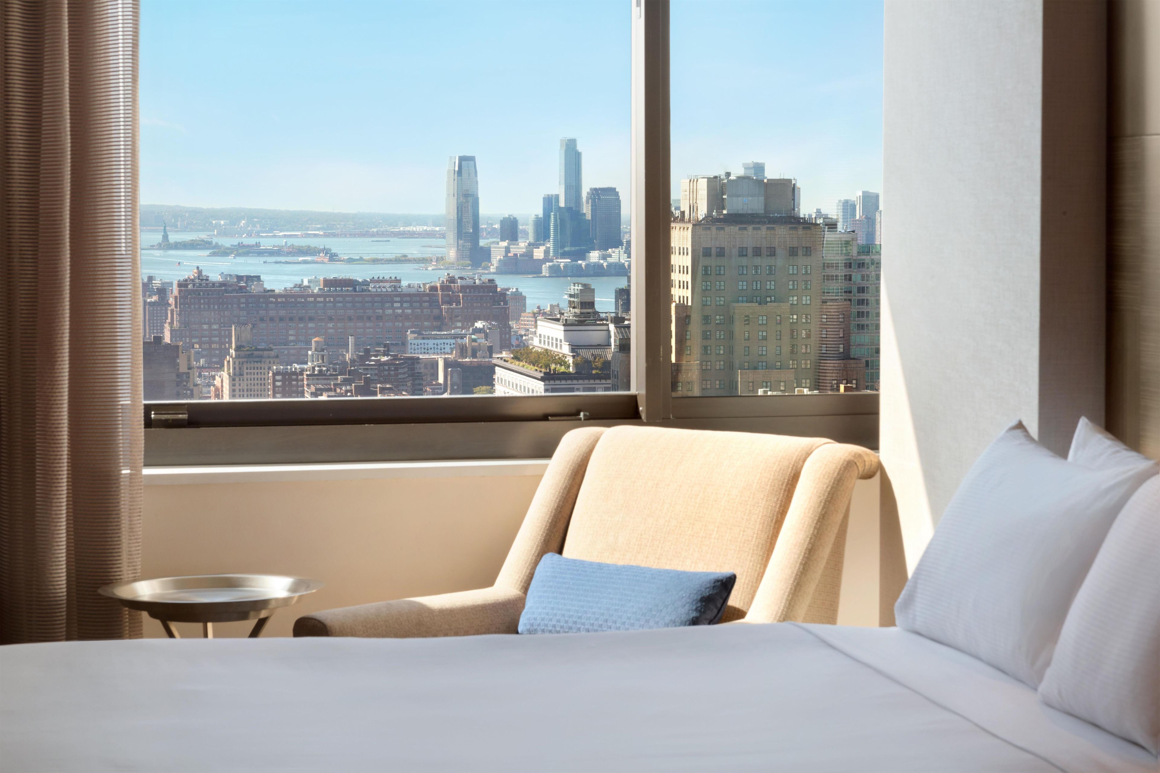 Een hotelkamer met een groot raam en uitzicht over de stad.