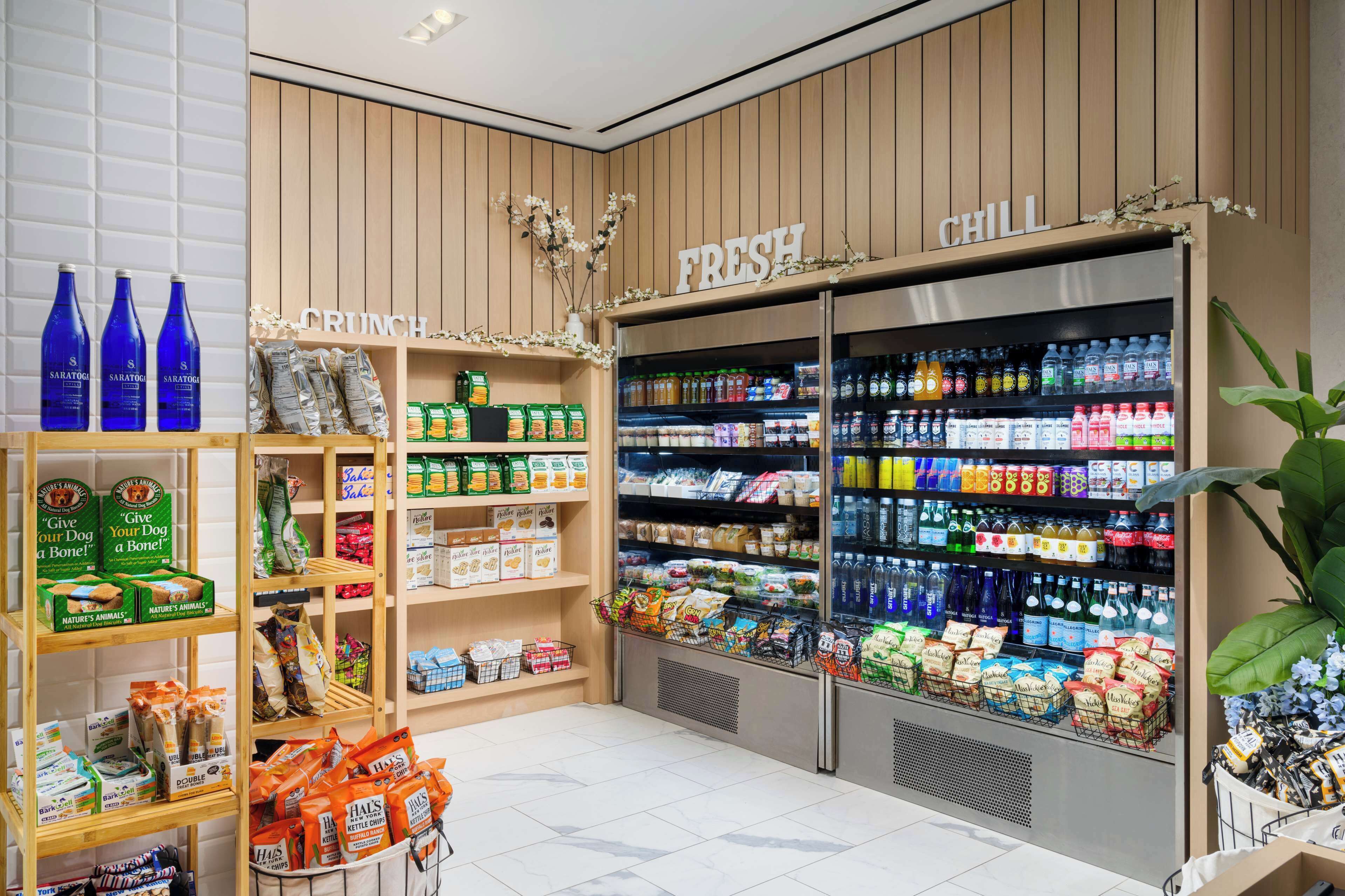 Un supermercado con estantes llenos de aperitivos, bebidas y comida para mascotas.
