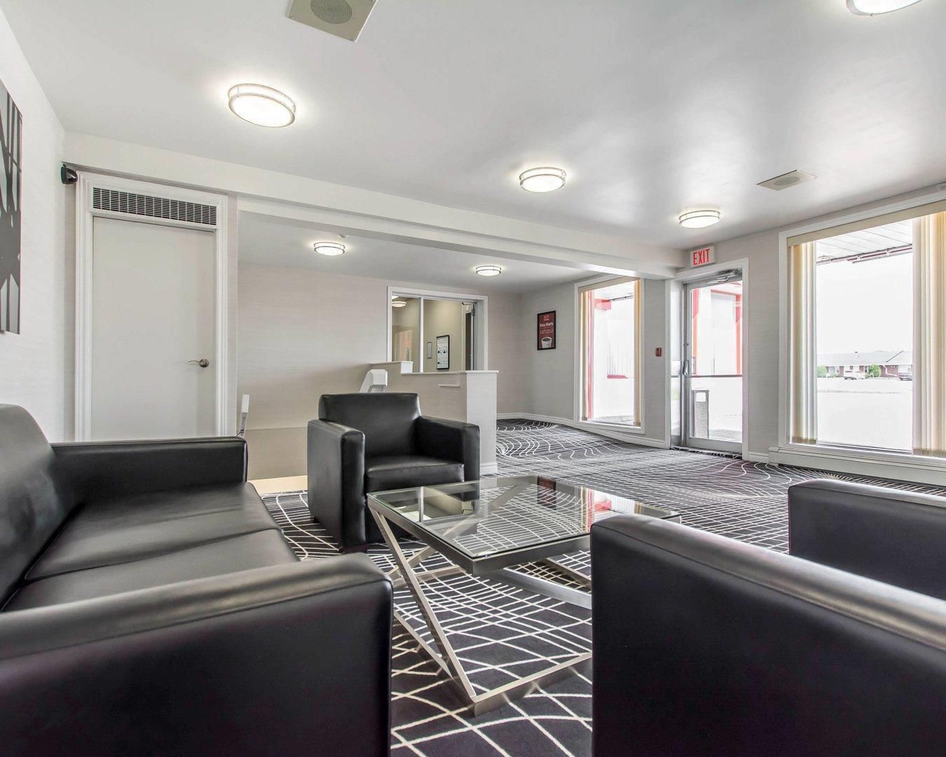 A hotel lobby with seating, a reception desk, and a view of the outside.