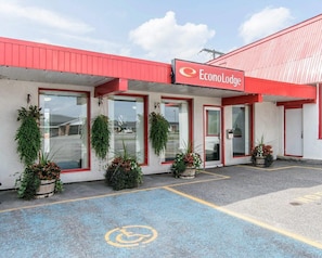 A building with a red roof and a sign reading 'EconoLodge.' There are potted plants in front of the entrance. - Econo Lodge (Temiskaming Shores)
