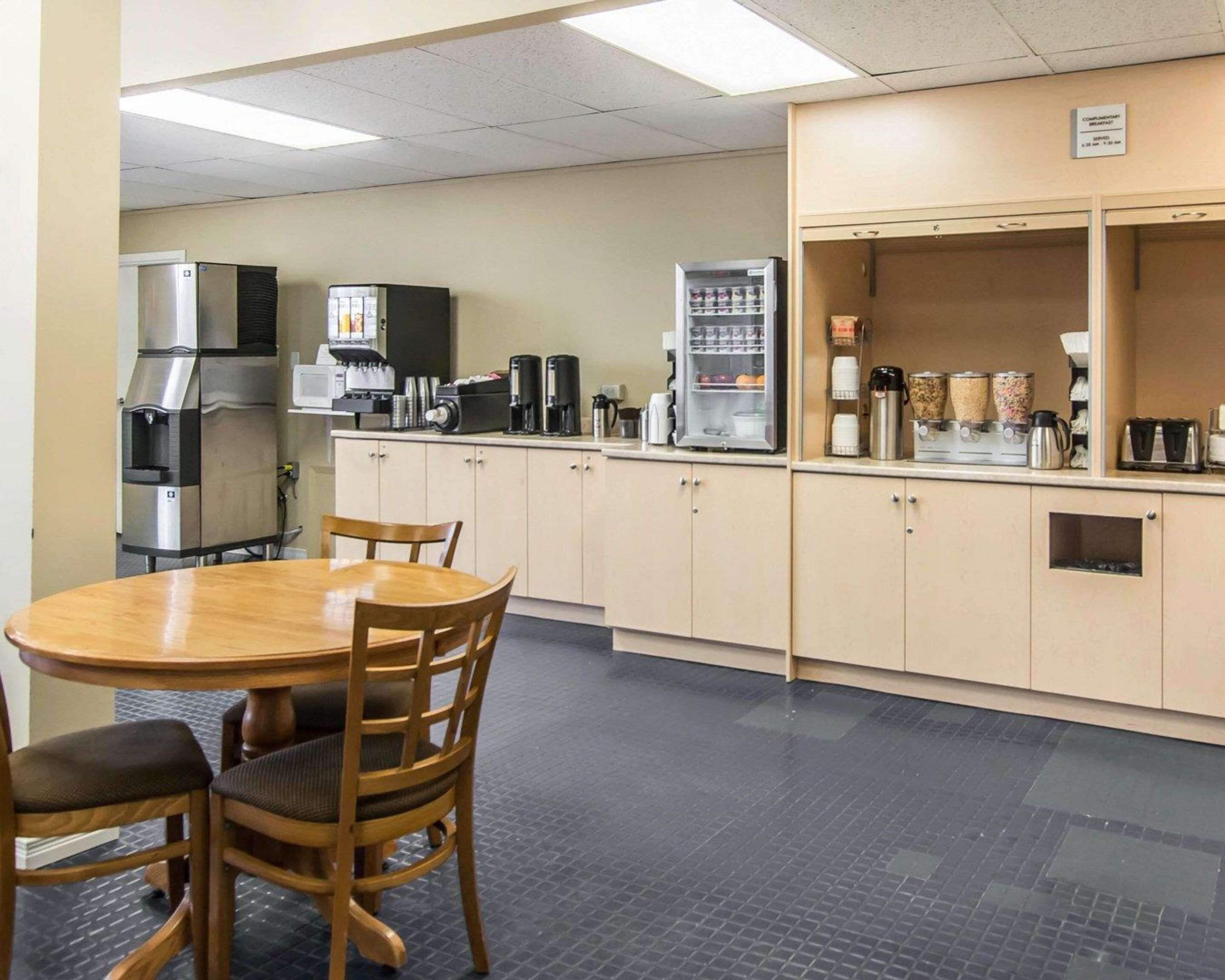 A compact kitchenette with a refrigerator, coffee maker, and a microwave.
