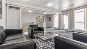 A hotel lobby with a reception desk, seating area, and large windows. - Econo Lodge (Temiskaming Shores)