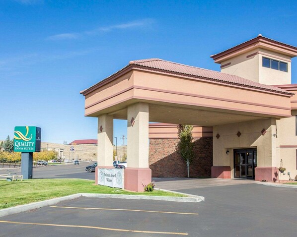 A hotel entrance with a covered parking area, a sign indicating a Platinum Award Winner, and a clear blue sky.