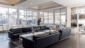 A modern lounge area with leather sofas, white tables, and large windows offering views of the city. - Lorraine Hotel (Miami Beach)