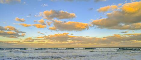 A beach with waves and a clear sky.