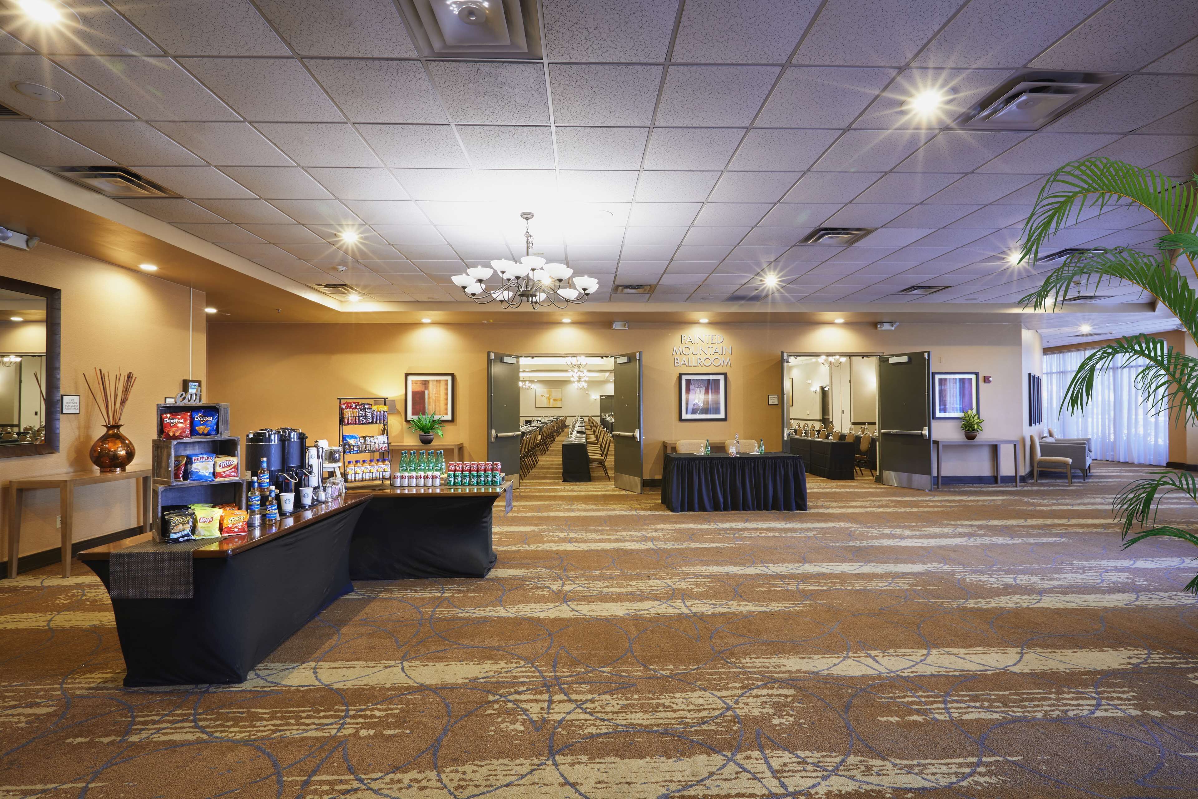 A hotel lobby with a reception desk, a buffet area, and a seating area.