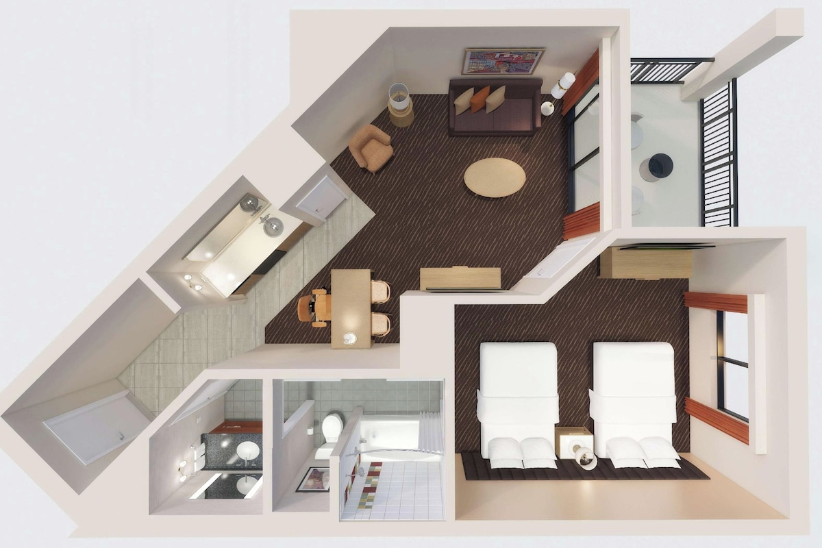 Distribución de una habitación de hotel con cama, zona de estar, kitchenette, baño y balcón.