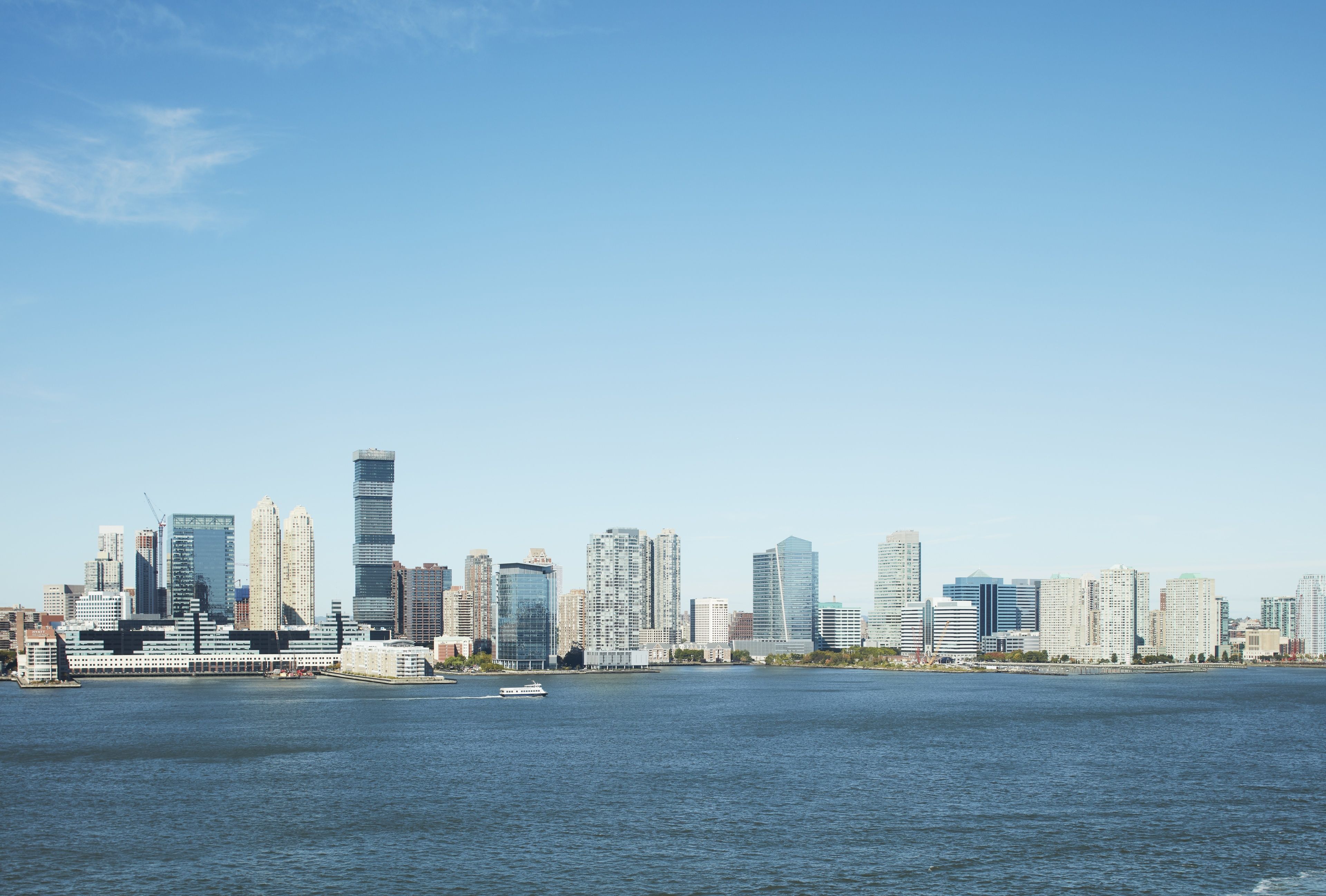 A city skyline with modern high-rise buildings across a body of water.