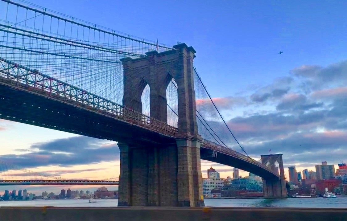 A large suspension bridge with two towers and a roadway spanning a body of water.