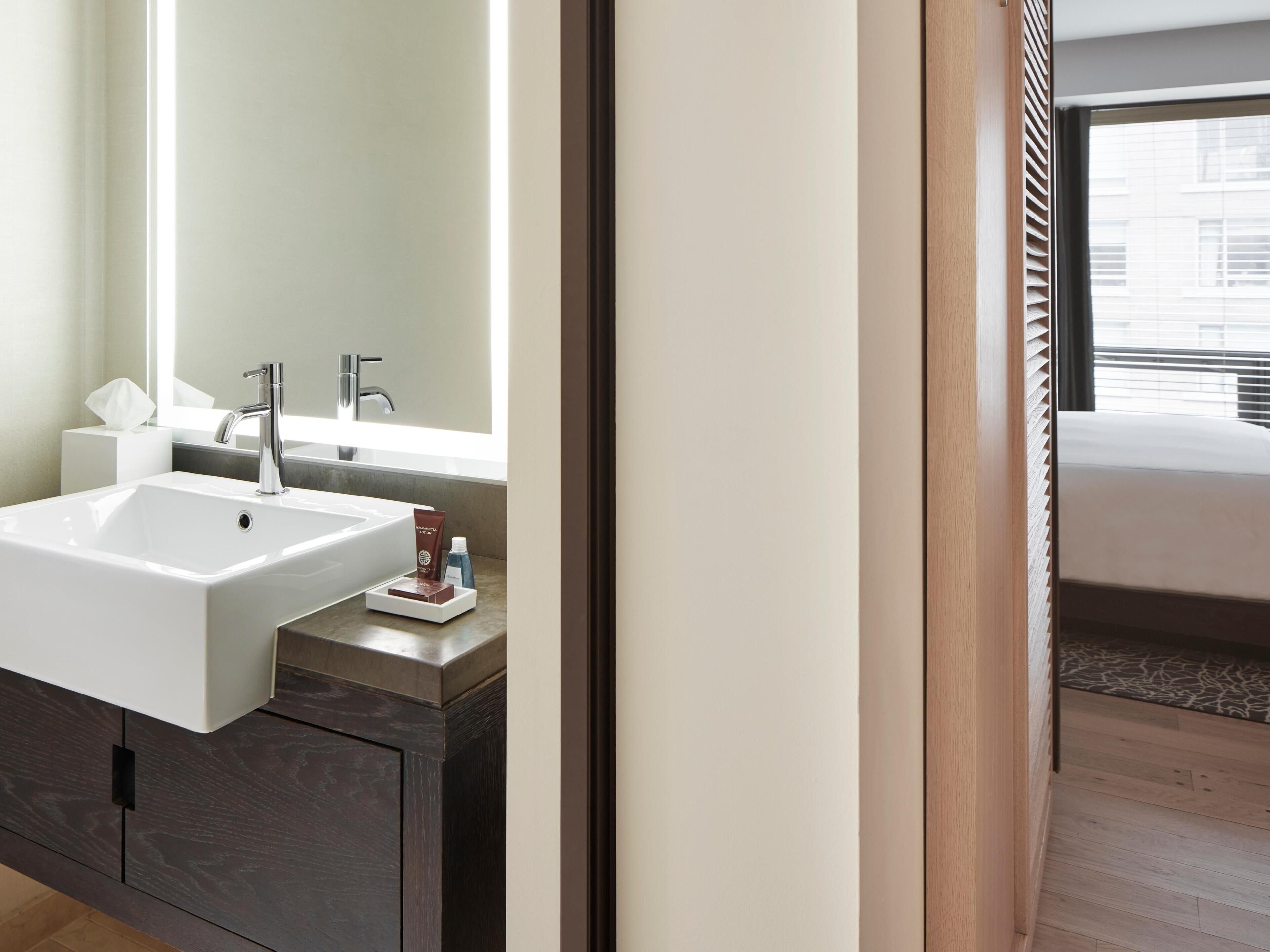 Un baño moderno con un lavamanos grande, un espejo y artículos de aseo.