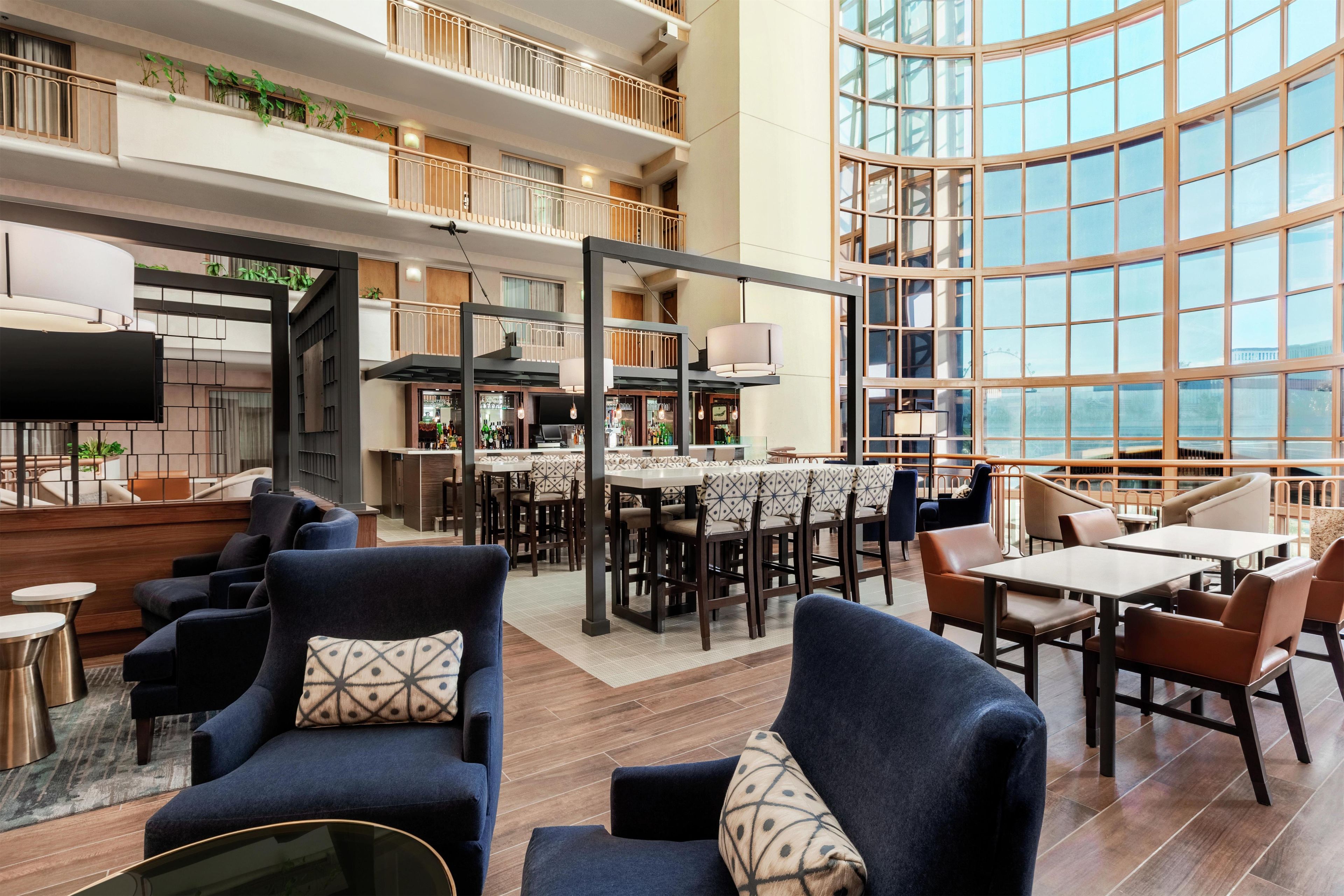A spacious indoor area with multiple seating arrangements, including sofas and tables, and a large window providing a view.
