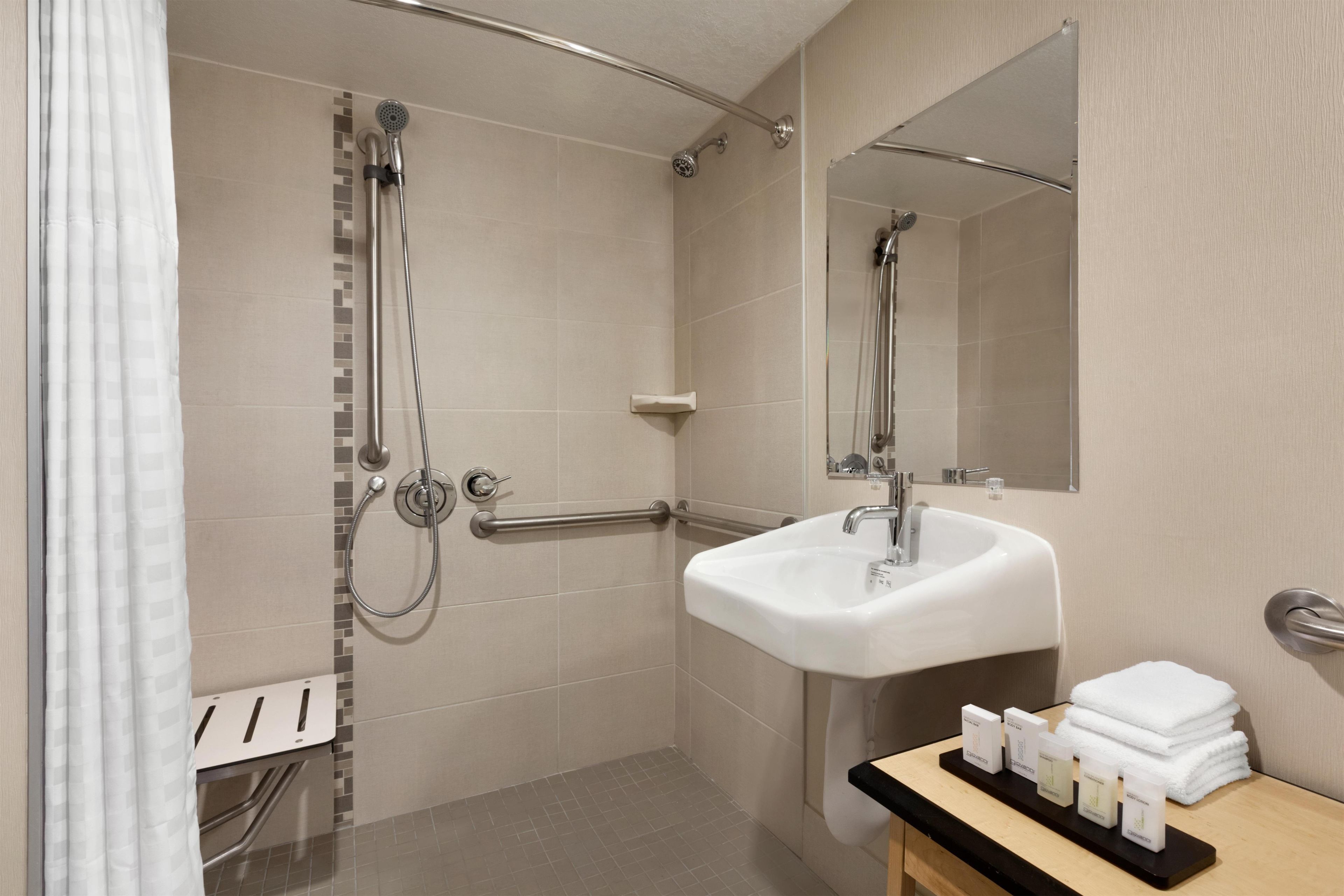 A modern bathroom with a shower, a sink, and a mirror.