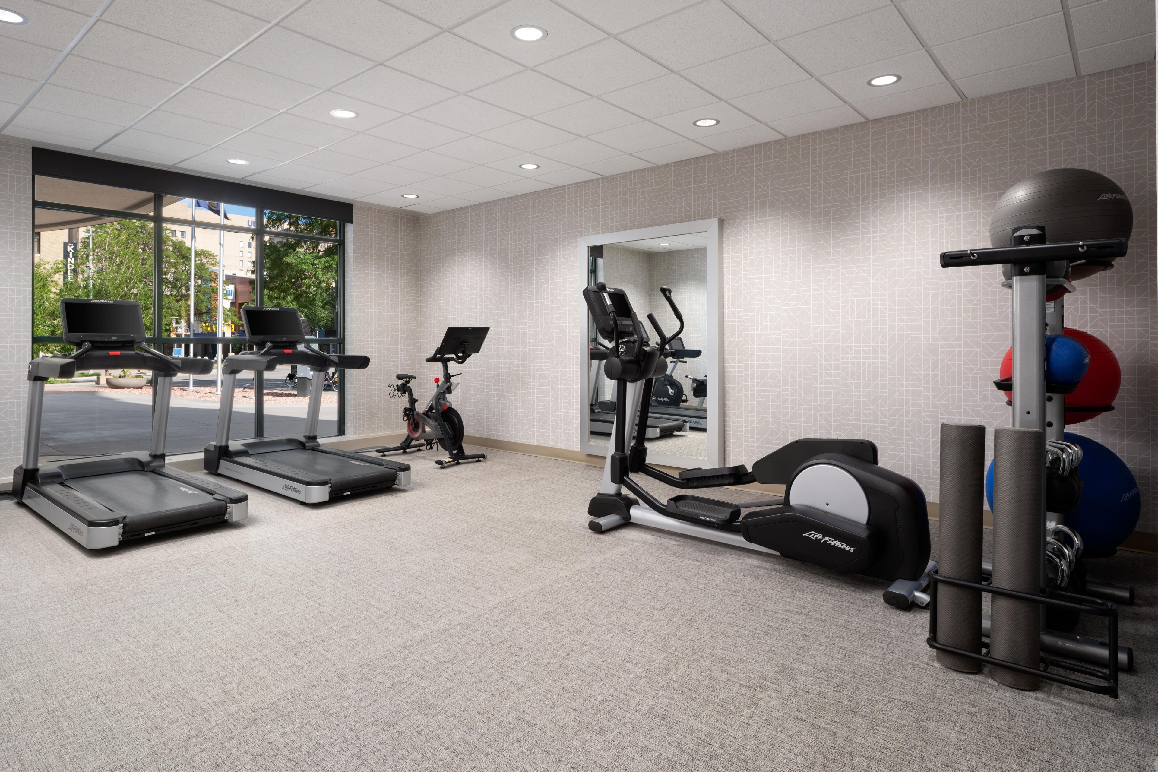 A gym with treadmills, an elliptical, and exercise balls.