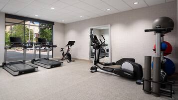 A gym with treadmills, an elliptical, and exercise balls.