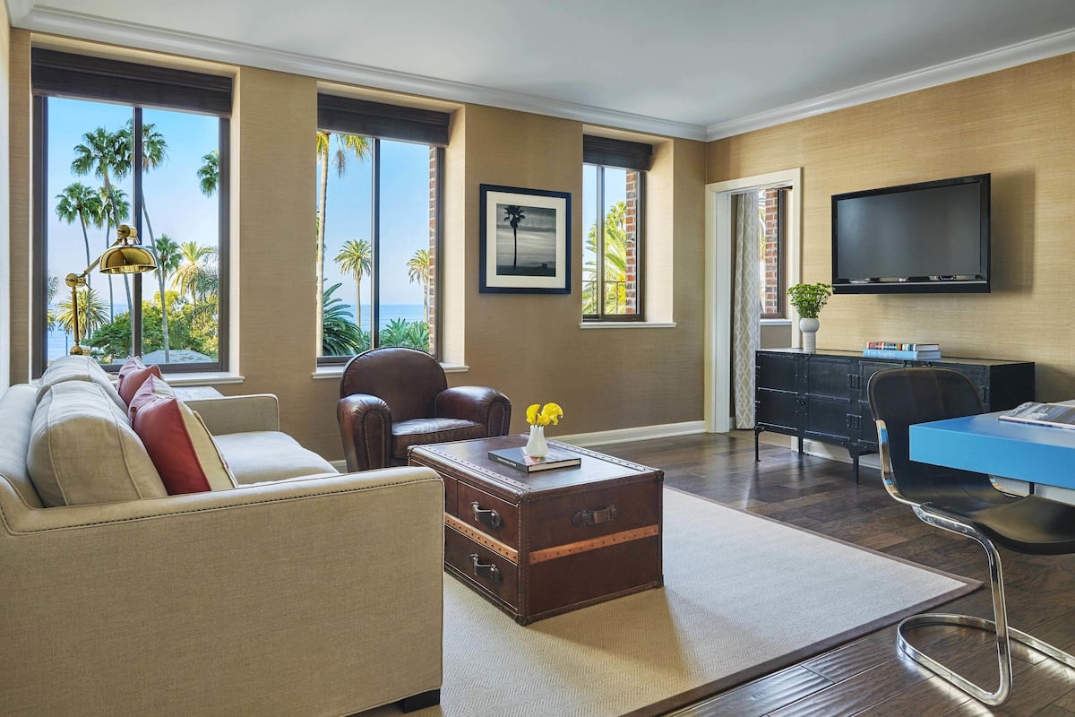 A living room with a sofa, a coffee table, a TV, and a desk.