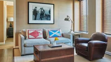 A living room with a sofa, a brown leather armchair, a wooden coffee table, and a framed picture on the wall.
