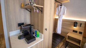 A modern bathroom with a wooden vanity, a coffee machine, and a towel rack.