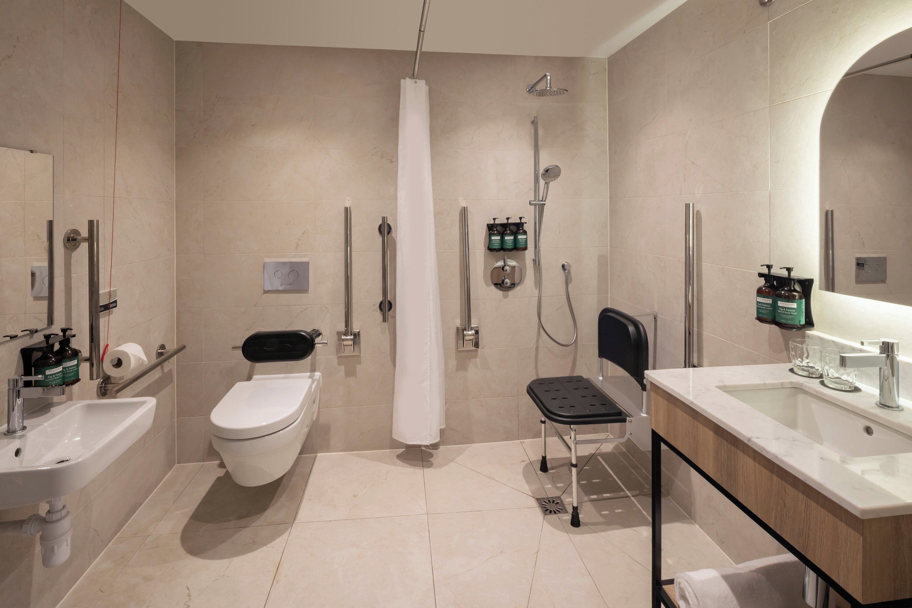 Une salle de bain moderne équipée de toilettes, d’un bidet, d’une douche et d’un lavabo.