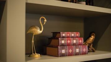 A bookshelf with decorative items including a golden flamingo, stacked books, and a small owl figurine.