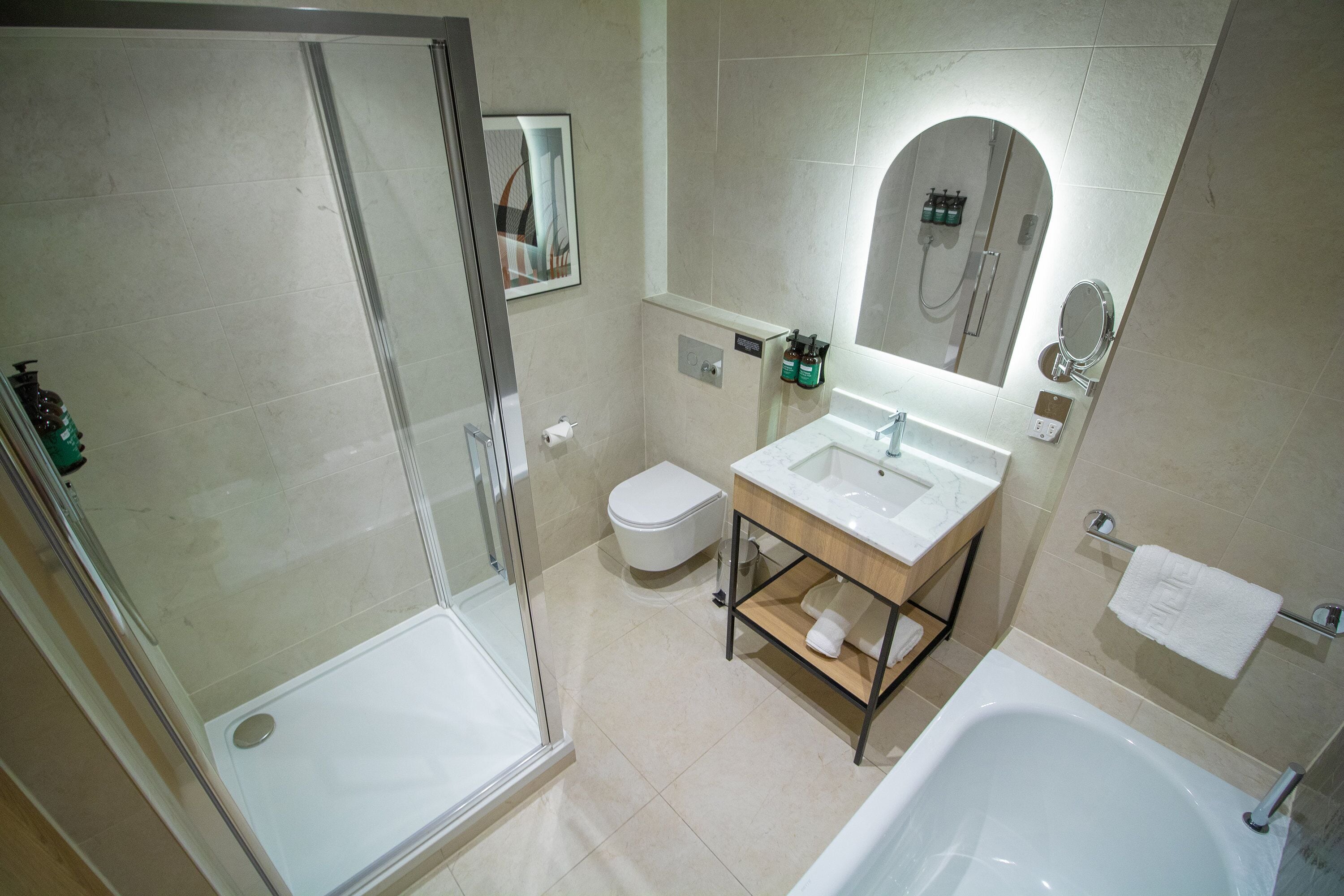Une salle de bain moderne avec une douche à parois de verre, un lavabo blanc et une baignoire.