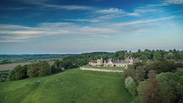 A large estate with a prominent manor house surrounded by lush green fields and trees.