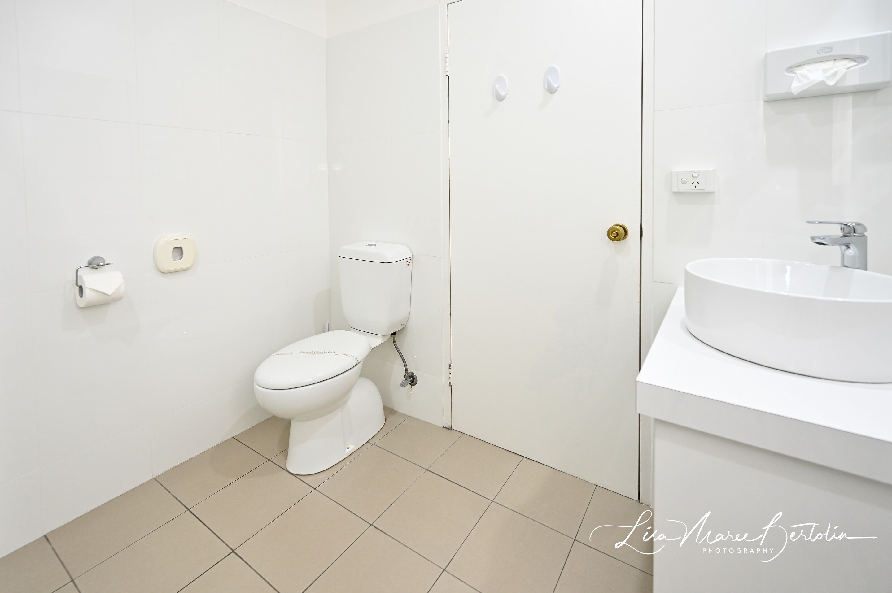 A modern bathroom with a toilet, sink, and mirror.