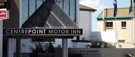 A building with a sign that reads "CENTREPOINT MOTOR INN" and another sign stating "FREE WI-FI INTERNET".