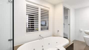 Une salle de bain moderne avec une baignoire sur pieds, une douche à parois de verre et des toilettes.