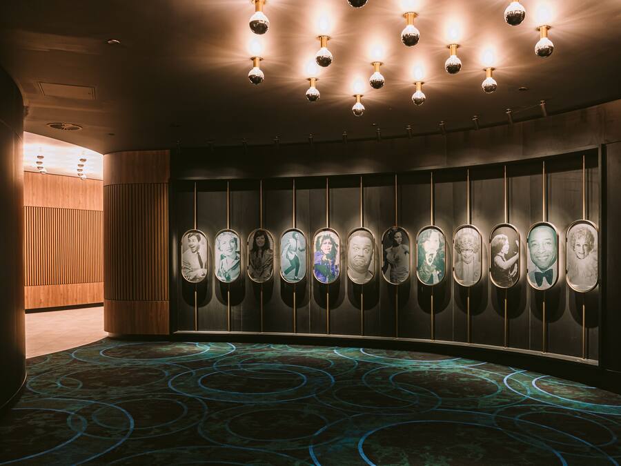 A modern restroom with illuminated wall-mounted urinals and a patterned floor.