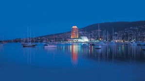 Un port de plaisance avec des bateaux et un bâtiment imposant dont les fenêtres sont illuminées.