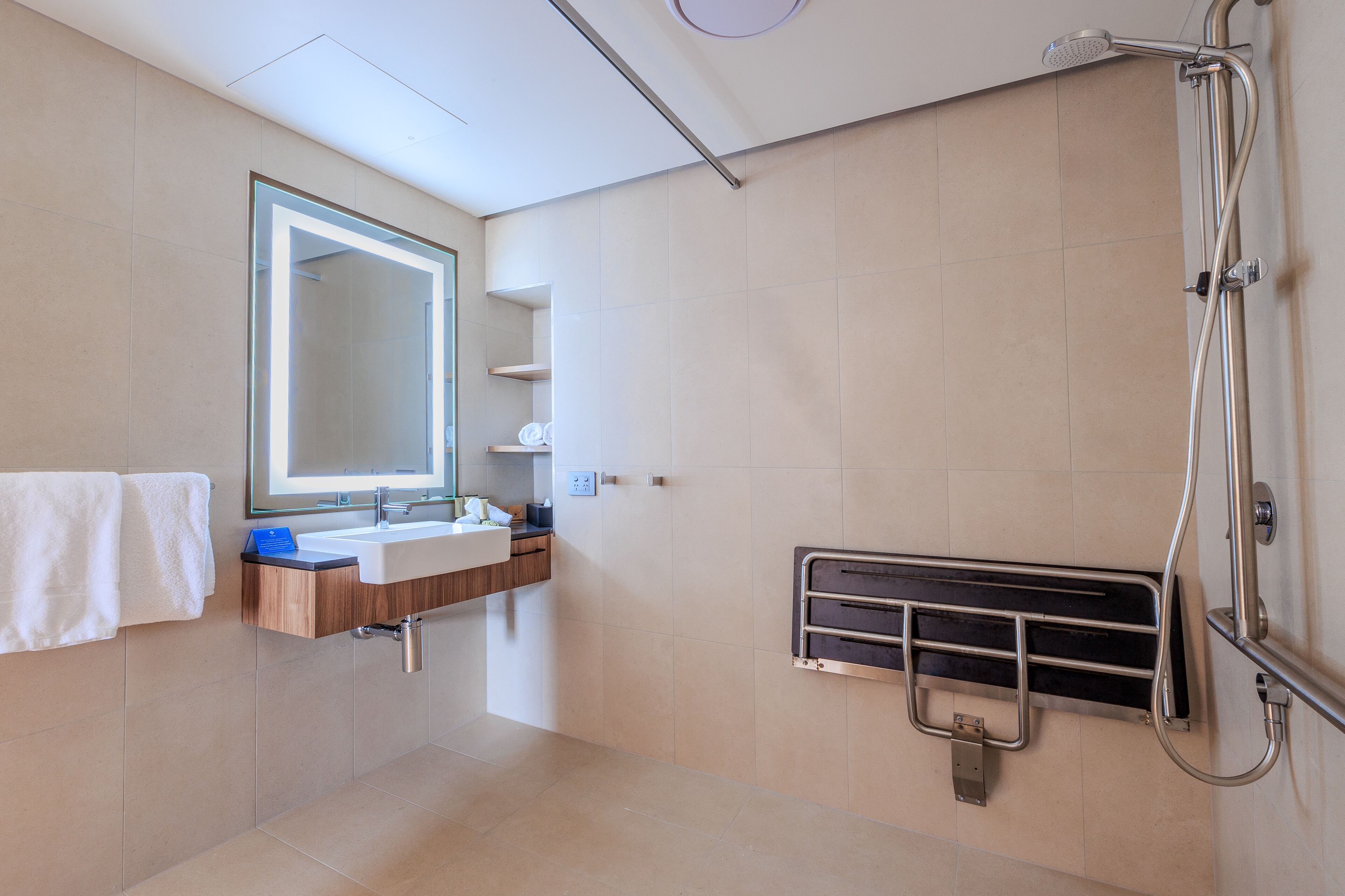 Un baño moderno con un espejo grande, un lavabo y una ducha.