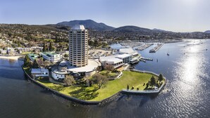 Vue aérienne d’une propriété située au bord de l’eau, avec un bâtiment central, une marina et des quartiers résidentiels environnants.