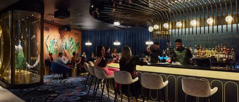 A bar area with a curved ceiling, bar stools, and a seating area with tables.