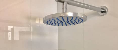 A shower with a handheld spray head mounted on a wall.