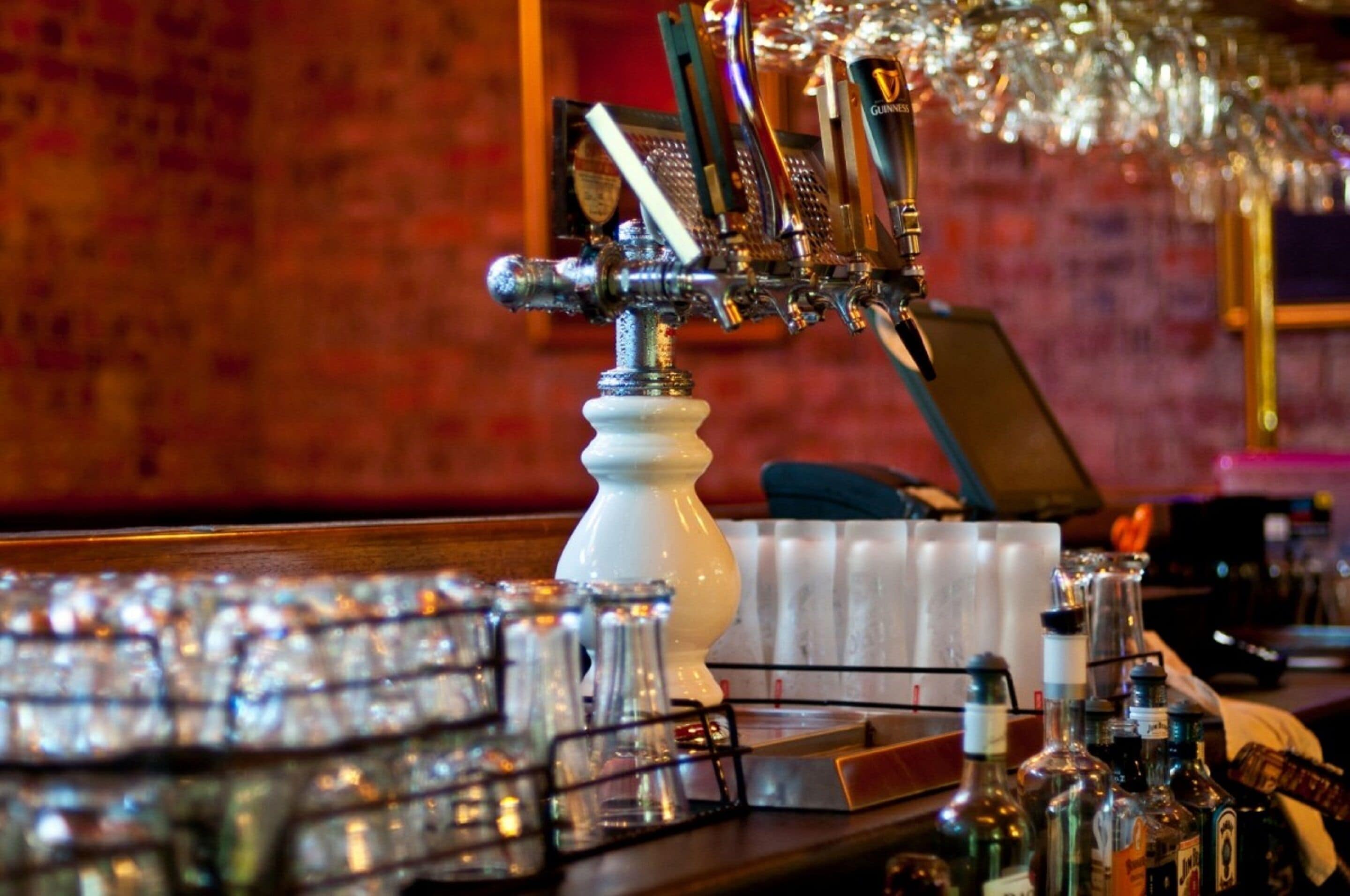 Un espace bar avec un robinet, des verres et des bouteilles.