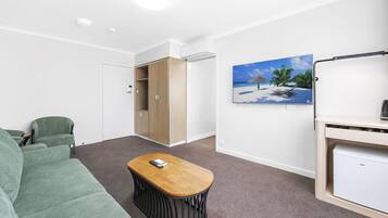 Deluxe kamer, 1 queensize bed met slaapbank | Woonruimte | Flatscreentelevisie