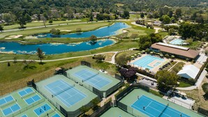 An aerial view of a golf course with multiple tennis courts, a swimming pool, and a clubhouse. - Carmel Valley Ranch, in The Unbound Collection by Hyatt (Carmel)