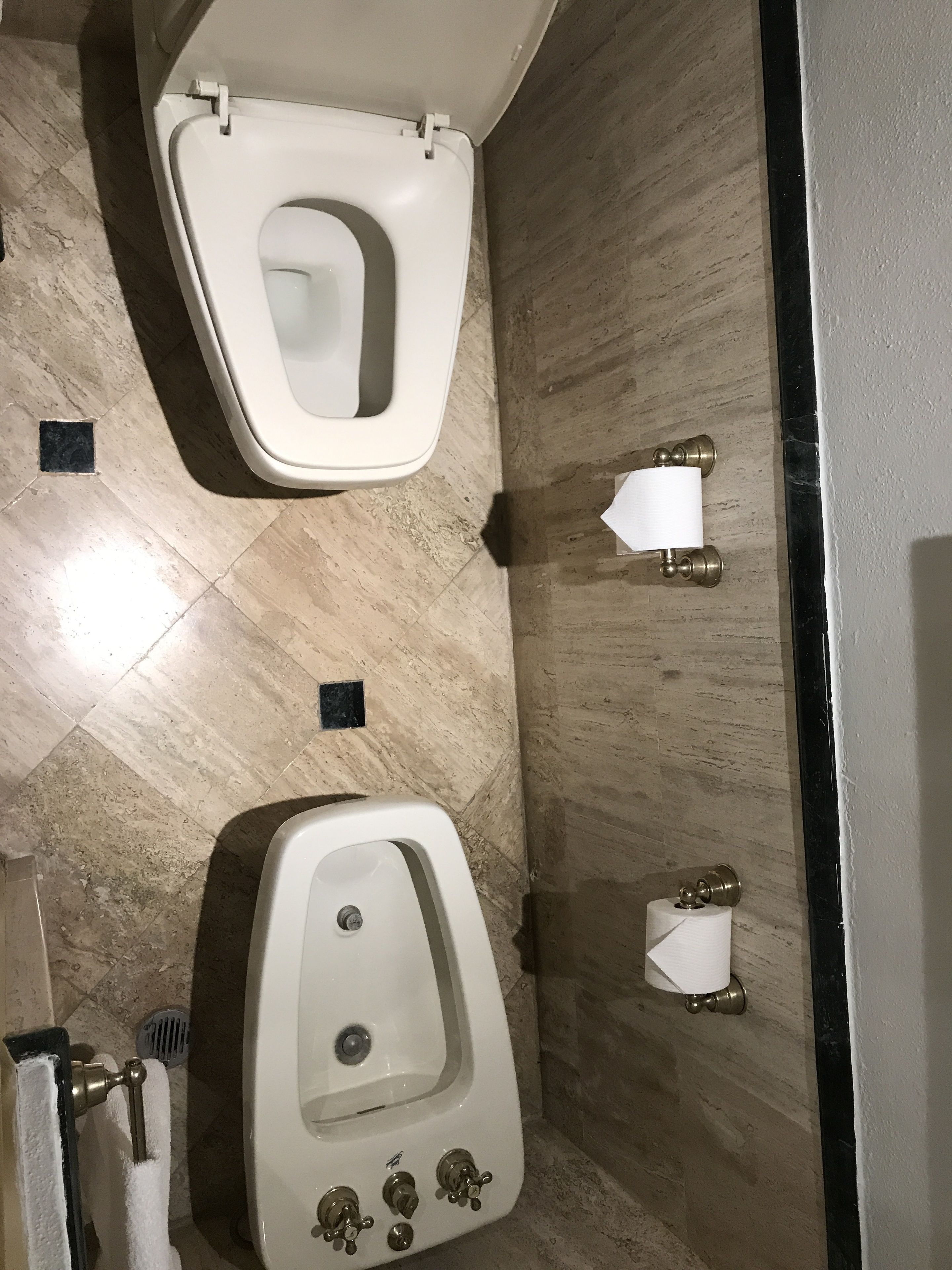 A modern bathroom with a toilet, urinal, and a sink.