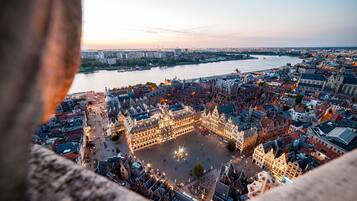 A historic city square with a prominent building featuring a large central courtyard and surrounding architecture.