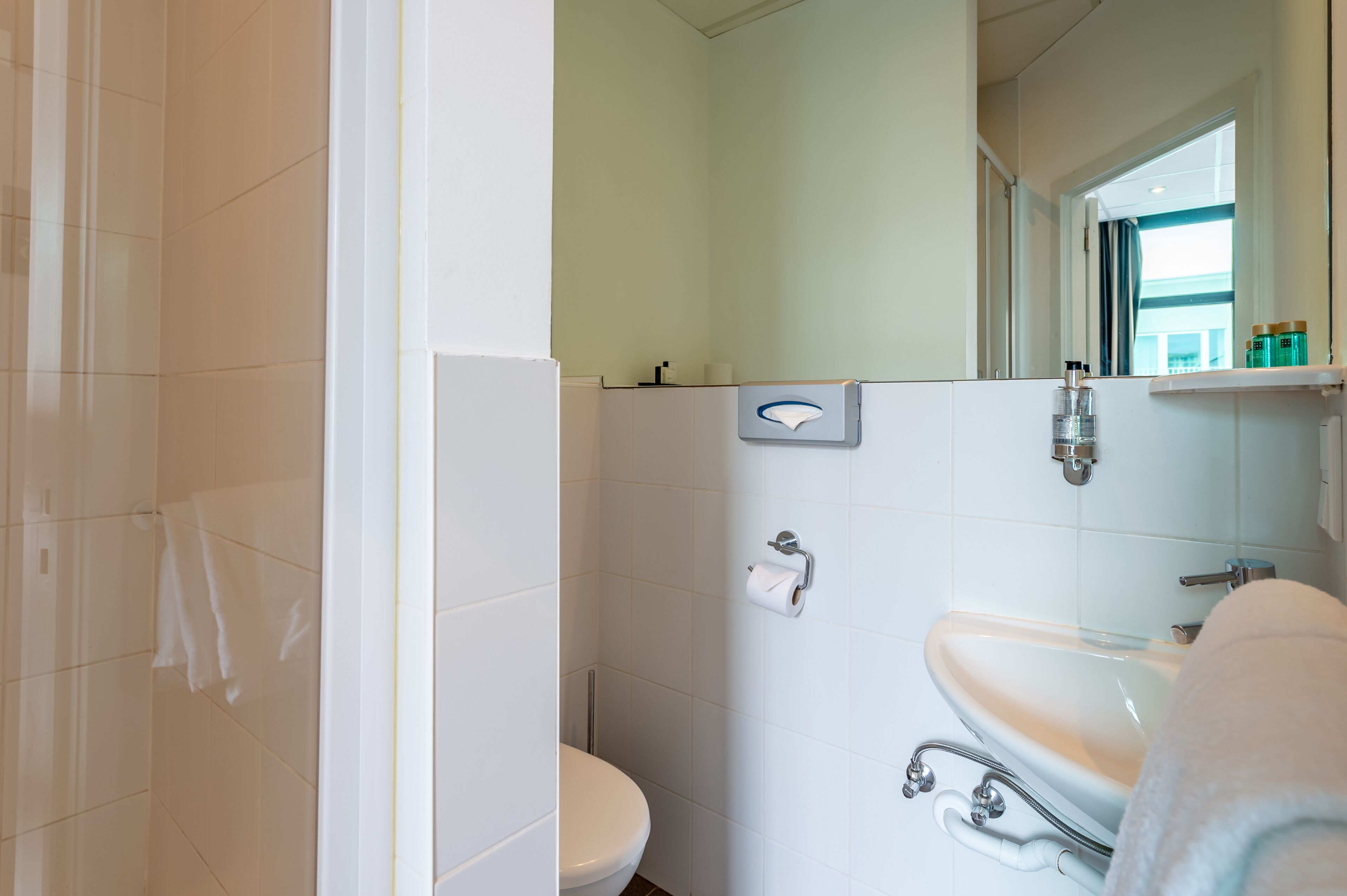 A bathroom with a toilet, sink, and shower.