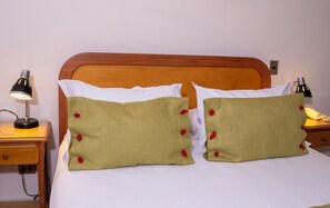 A bed with two green pillows with red buttons, a wooden headboard, and two bedside lamps. - Hotel Canciller - Ex Hotel Presidente (Santiago)