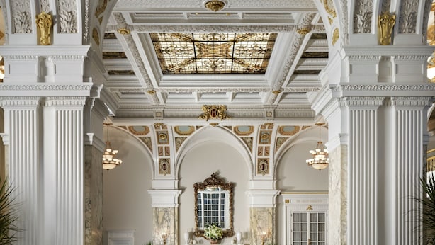 A grand lobby with high ceilings, ornate columns, and a central fireplace. - The Hermitage Hotel (Nashville)
