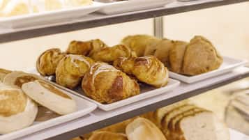 Una vitrina de panadería con diversos productos horneados, incluyendo pasteles y pan.