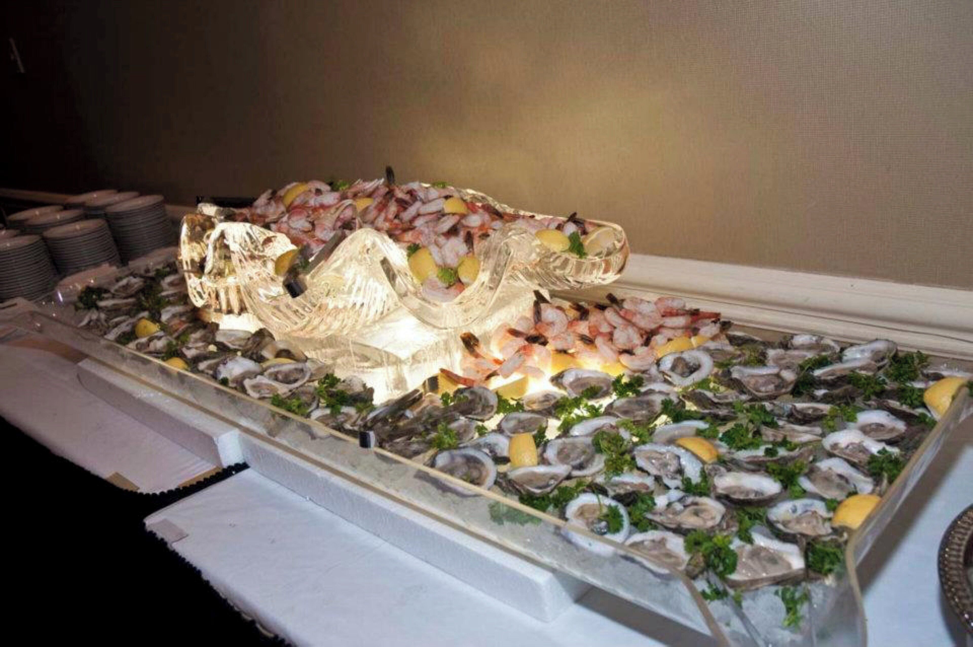Un présentoir de fruits de mer avec des huîtres, des crevettes et des tranches de citron.