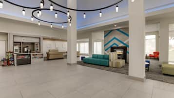 A spacious lobby with a reception desk, seating area, and a large wall with a geometric pattern.